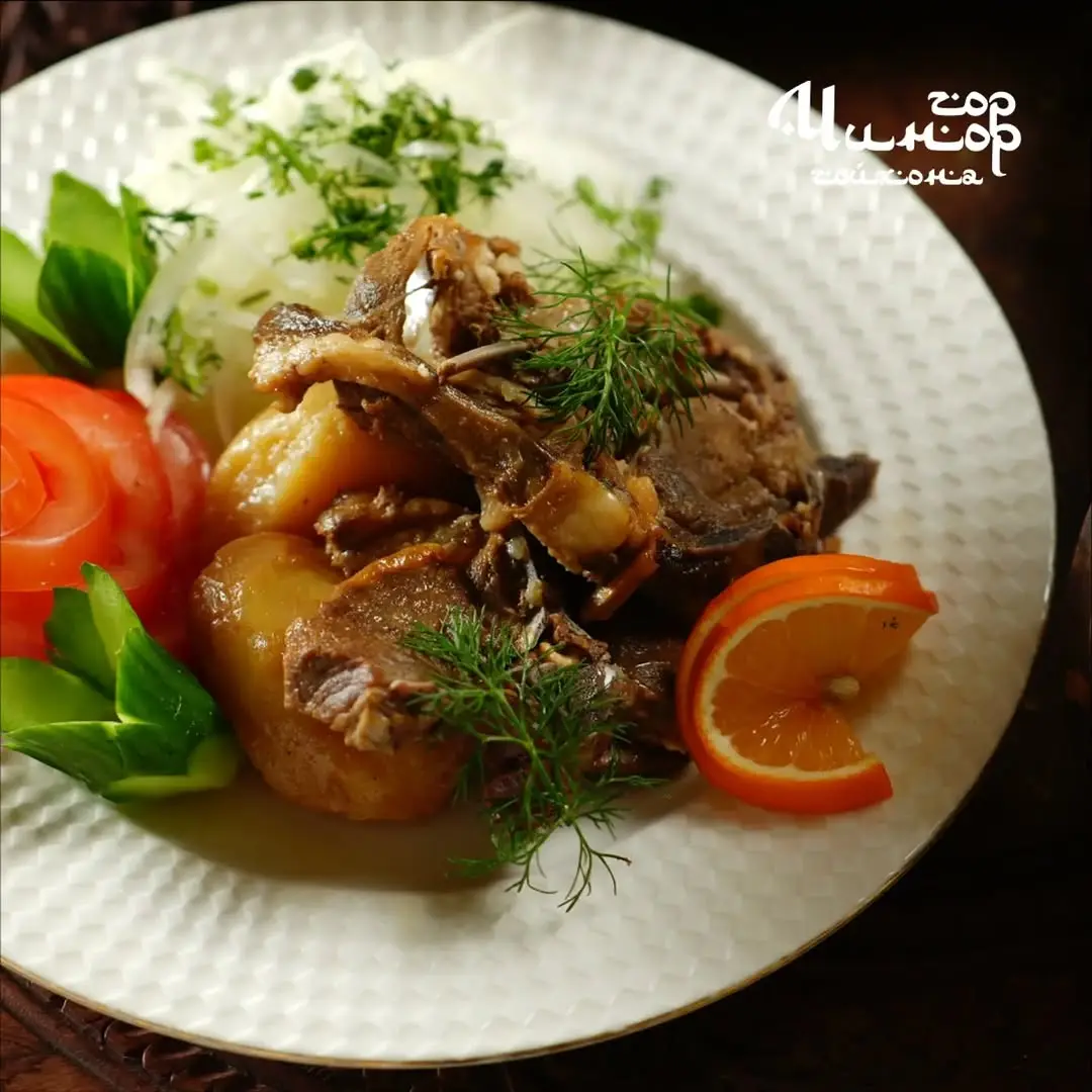 Тушёное мясо с картофелем и овощами на тарелке